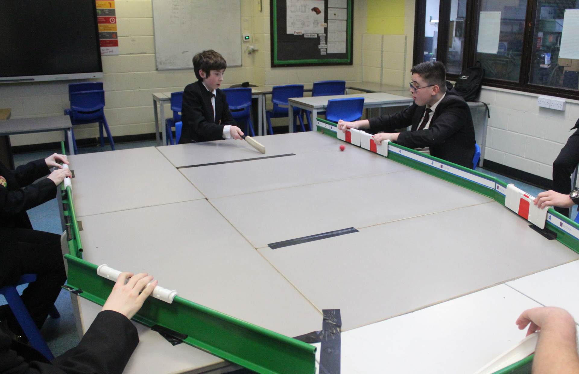 Students playing table top cricket